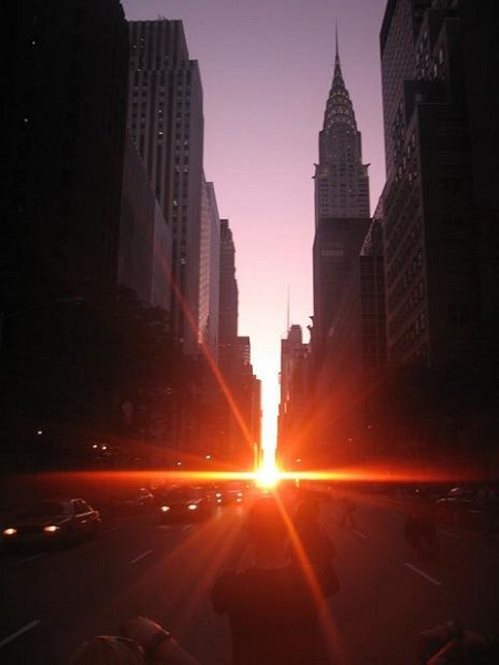 Manhattanhenge - Marvel at the breathtaking view of the sun setting perfectly between the towering skyscrapers of Manhattanhenge. The stunning image captures the beauty of nature and modern architecture in one frame.