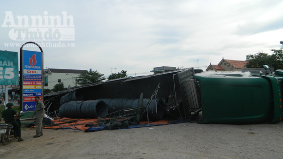 Xe container chở thép lật trước cây xăng - Hình 1