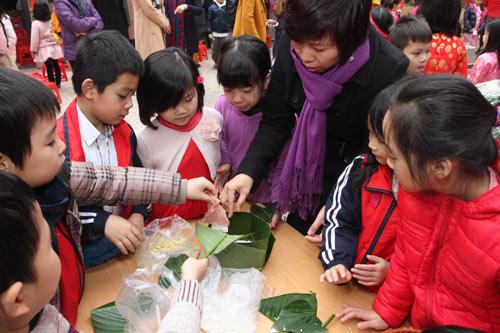 Học sinh tiểu học ngượng ngùng gói bánh chưng Tết - Hình 2