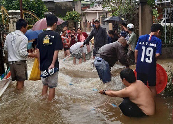 Lâm Đồng: Sau mưa lớn, dân phố ôm rổ, vợt, bu gà... ra đường bắt cá - Hình 1