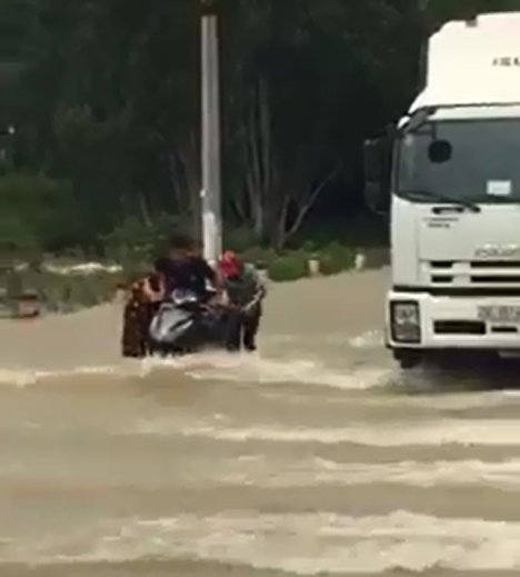 Thấy xe máy ì ạch vì nước lũ, tài xế xe tải chắn giúp để không bị trôi - Hình 3