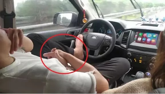 Tài xế lái xe bằng chân, tay bận âu yếm bạn gái trên đường cao tốc - Hình 1