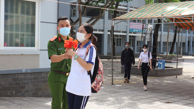 Chiến sĩ công an ở điểm thi ngồi kết hoa và hành động đặc biệt khi một nữ sinh làm xong bài bước ra - Hình 4