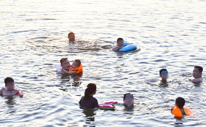 Hà Nội nắng nóng 37 độ C, người lớn, trẻ em biến hồ Linh Đàm thành bãi tắm để giải nhiệt - Hình 11