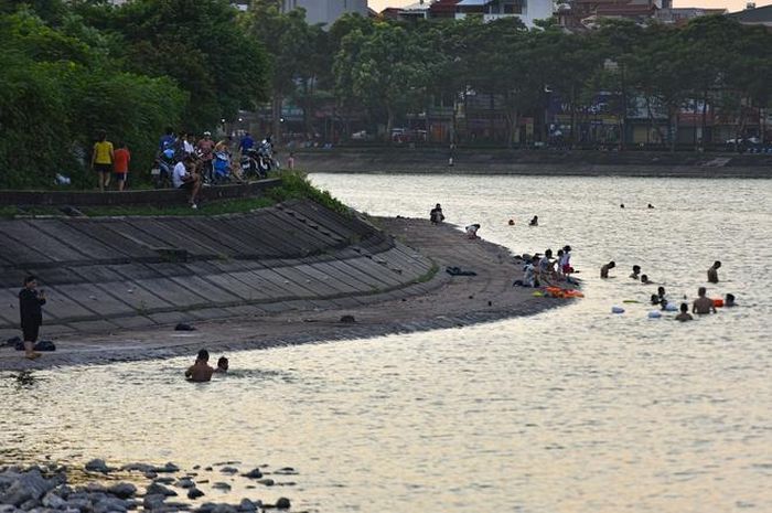 Hà Nội nắng nóng 37 độ C, người lớn, trẻ em biến hồ Linh Đàm thành bãi tắm để giải nhiệt - Hình 2