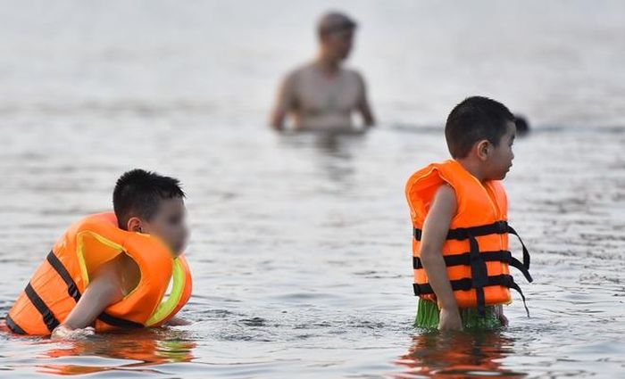 Hà Nội nắng nóng 37 độ C, người lớn, trẻ em biến hồ Linh Đàm thành bãi tắm để giải nhiệt - Hình 4