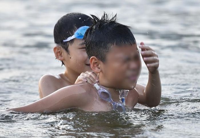 Hà Nội nắng nóng 37 độ C, người lớn, trẻ em biến hồ Linh Đàm thành bãi tắm để giải nhiệt - Hình 5