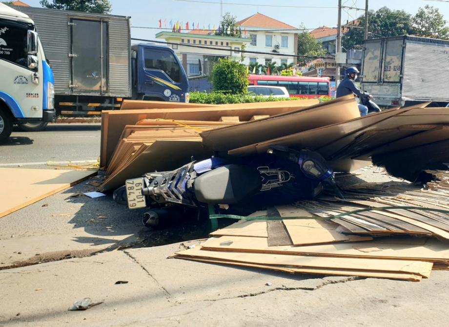 Hàng chục tấm ván ép đứt dây rơi xuống, đè trúng người đi xe máy ở Bình Dương - Hình 1
