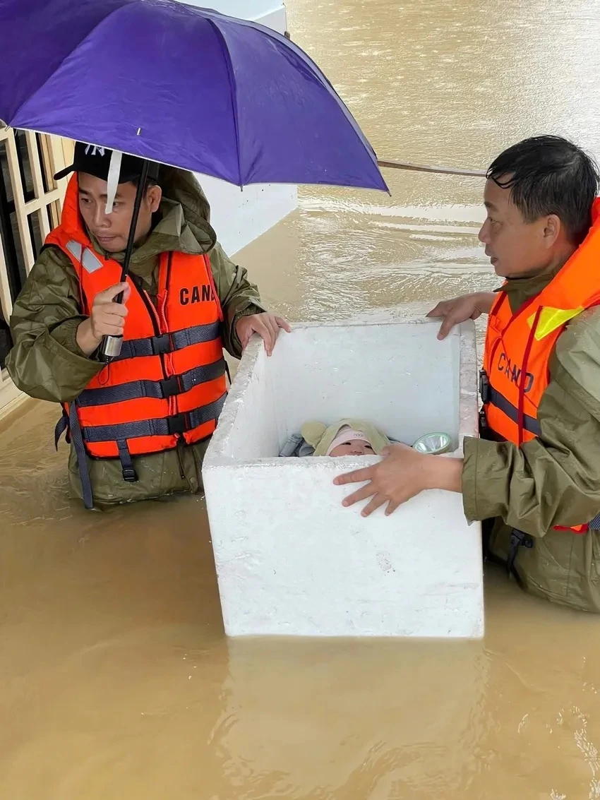 Em bé nằm ngoan trong thùng xốp khi được sơ tán khỏi vùng lũ Đà Nẵng - Hình 1