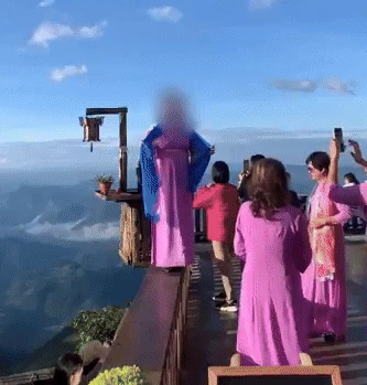 Nữ du khách trèo lên lan can, đứng chênh vênh chụp ảnh ở Tà Xùa gây xôn xao - Hình 1