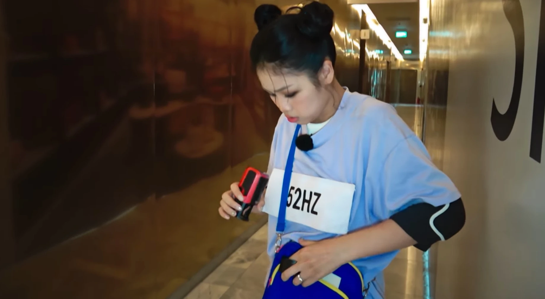 Cảnh 52Hz xoay bảng t&ecirc;n về ph&iacute;a trước ngực