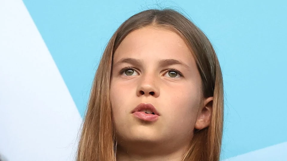 Charlotte đứng nghiêng nhẹ, dáng đứng thương hiệu Charlotte đứng nghiêng nhẹ người, tay dựa vào hàng rào, tạo dáng đứng thương hiệu