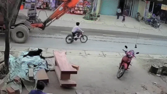 Bé trai đi xe đạp bị máy xúc tông, cuốn vào gầm - Hình 2