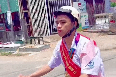 Nam sinh mang băng chéo, đeo huy chương trĩu cổ đi xe đạp về nhà - Hình 1
